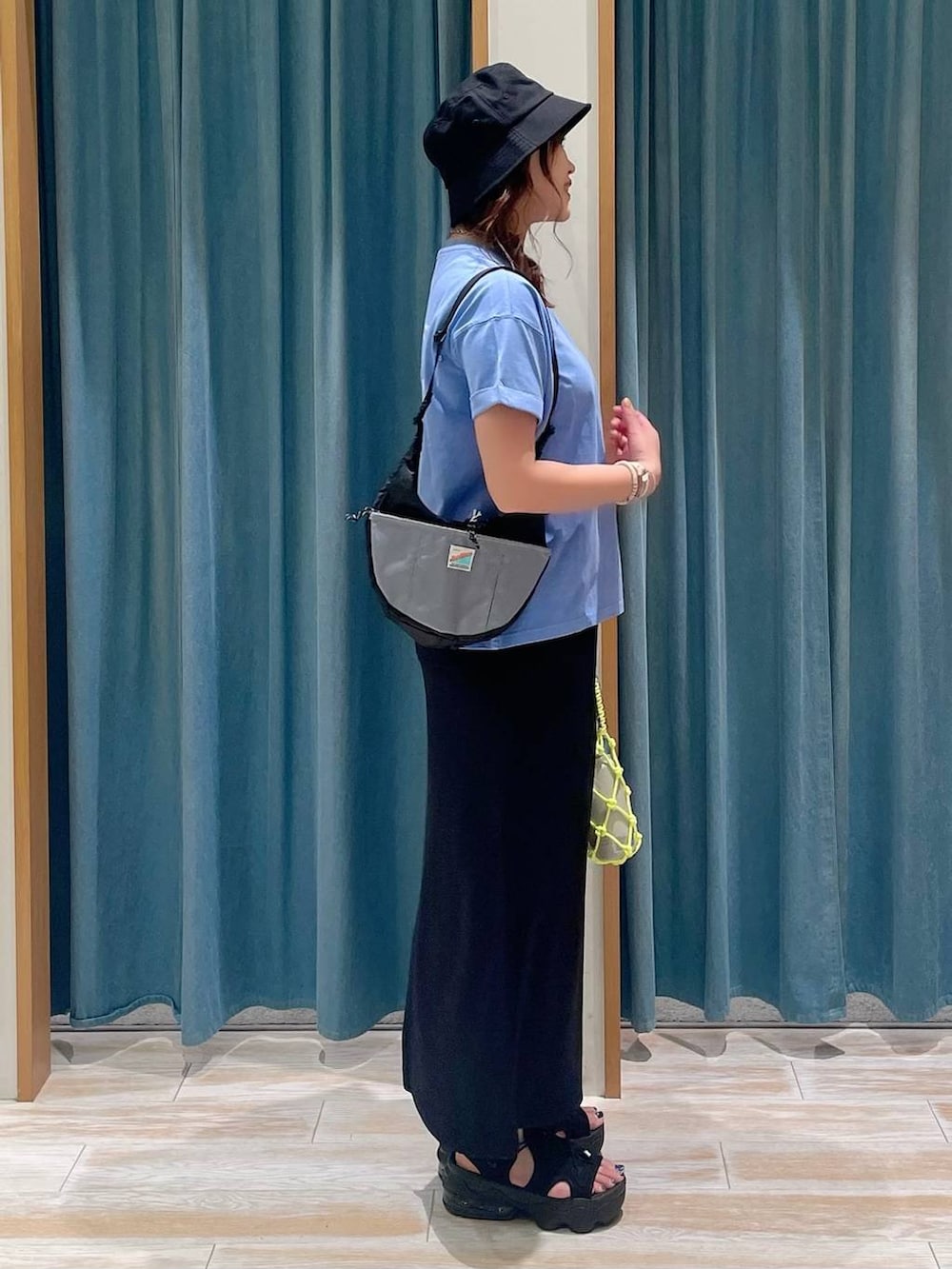 ブルー系のTシャツ/カットソー、ブラック系のショルダーバッグ、ブラック系のスカートを着用したレディースの夏コーディネートの2枚目の写真