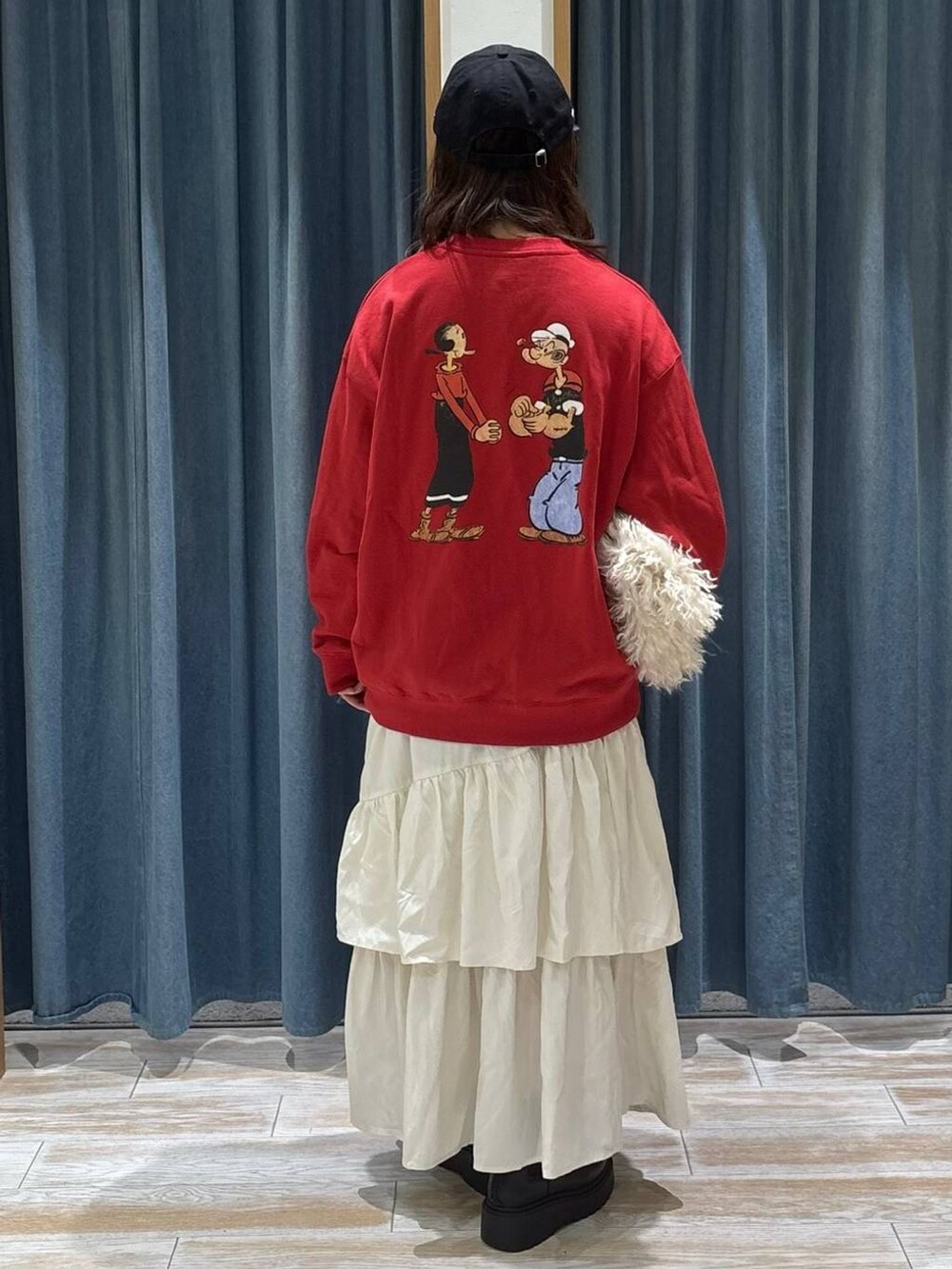 ブラック系のブーツ、ベージュ系のスカート、ベージュ系のショルダーバッグを着用したレディースの冬コーディネートの3枚目の写真