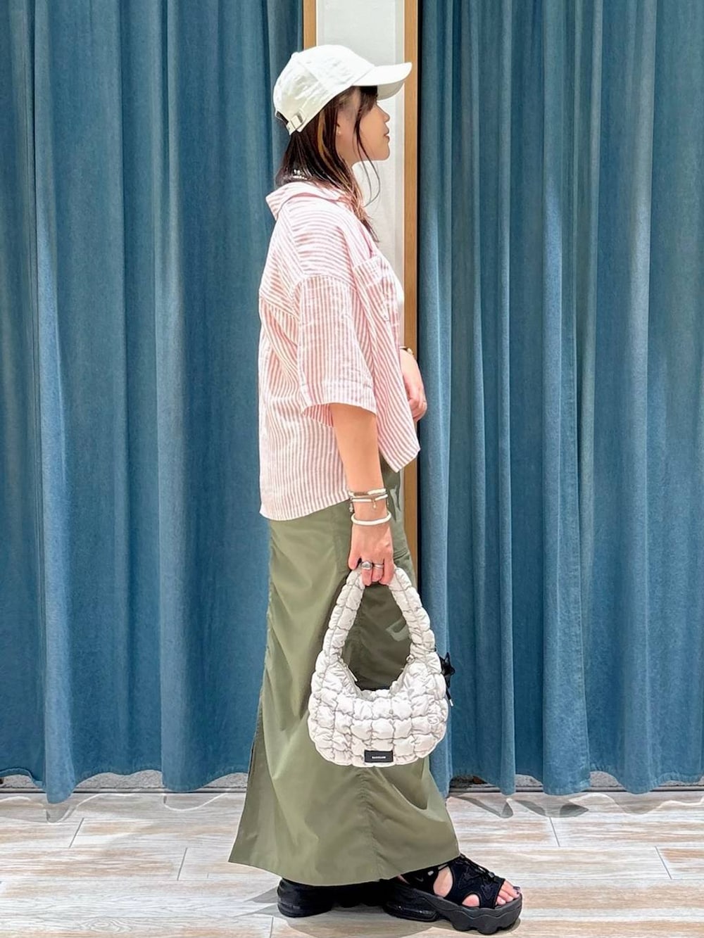 ホワイト系のキャミソール、グリーン系のスカート、レッド系のシャツ/ブラウスを着用したレディースの夏コーディネートの2枚目の写真