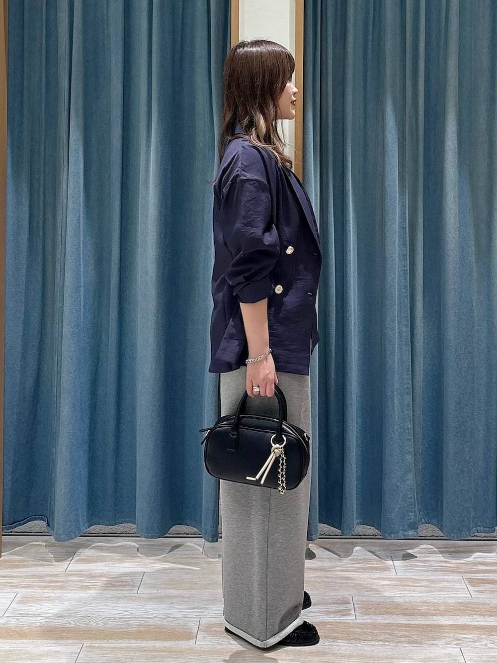 ブラック系のタンクトップ、ブラック系のローファー、ブラック系のハンドバッグを着用したレディースの春コーディネートの2枚目の写真