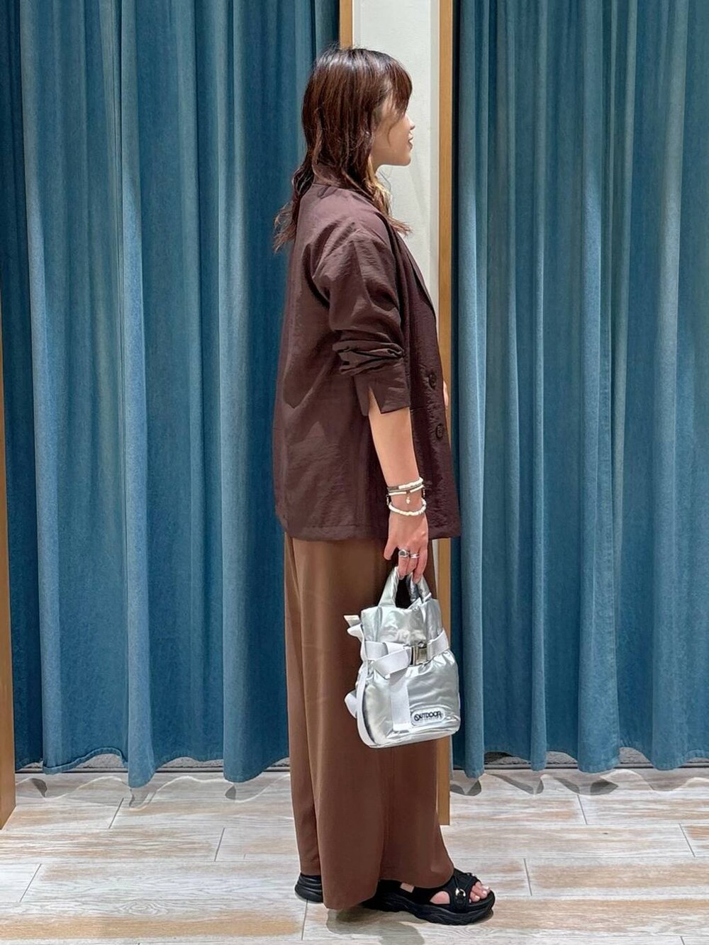 ブラック系のサンダル、ブラウン系のその他パンツ、ブラウン系のテーラードジャケットを着用したレディースの夏コーディネートの2枚目の写真