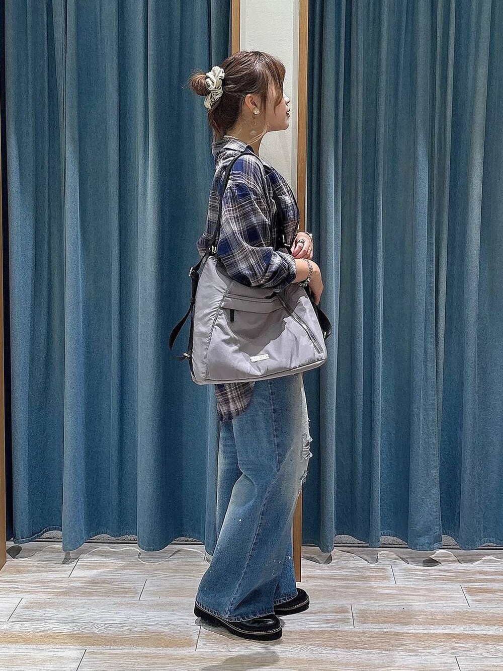 ブルー系のデニムパンツ、グレー系のバックパック/リュック、ブラック系のローファーを着用したレディースの秋コーディネートの2枚目の写真