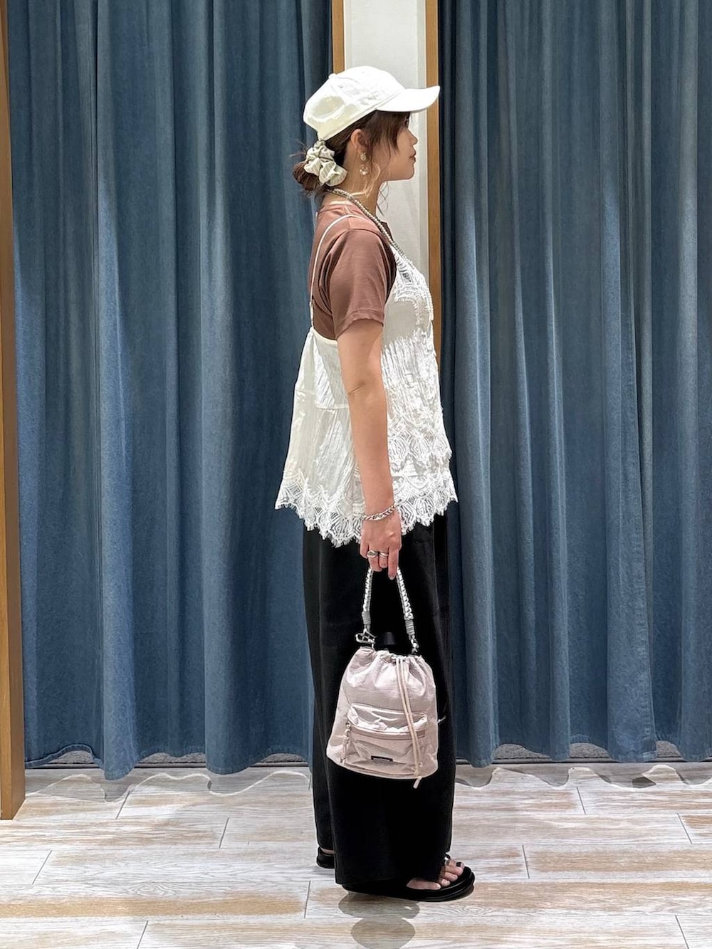 グレー系のその他パンツ、ピンク系のショルダーバッグ、ブラック系のサンダルを着用したレディースの夏コーディネートの2枚目の写真
