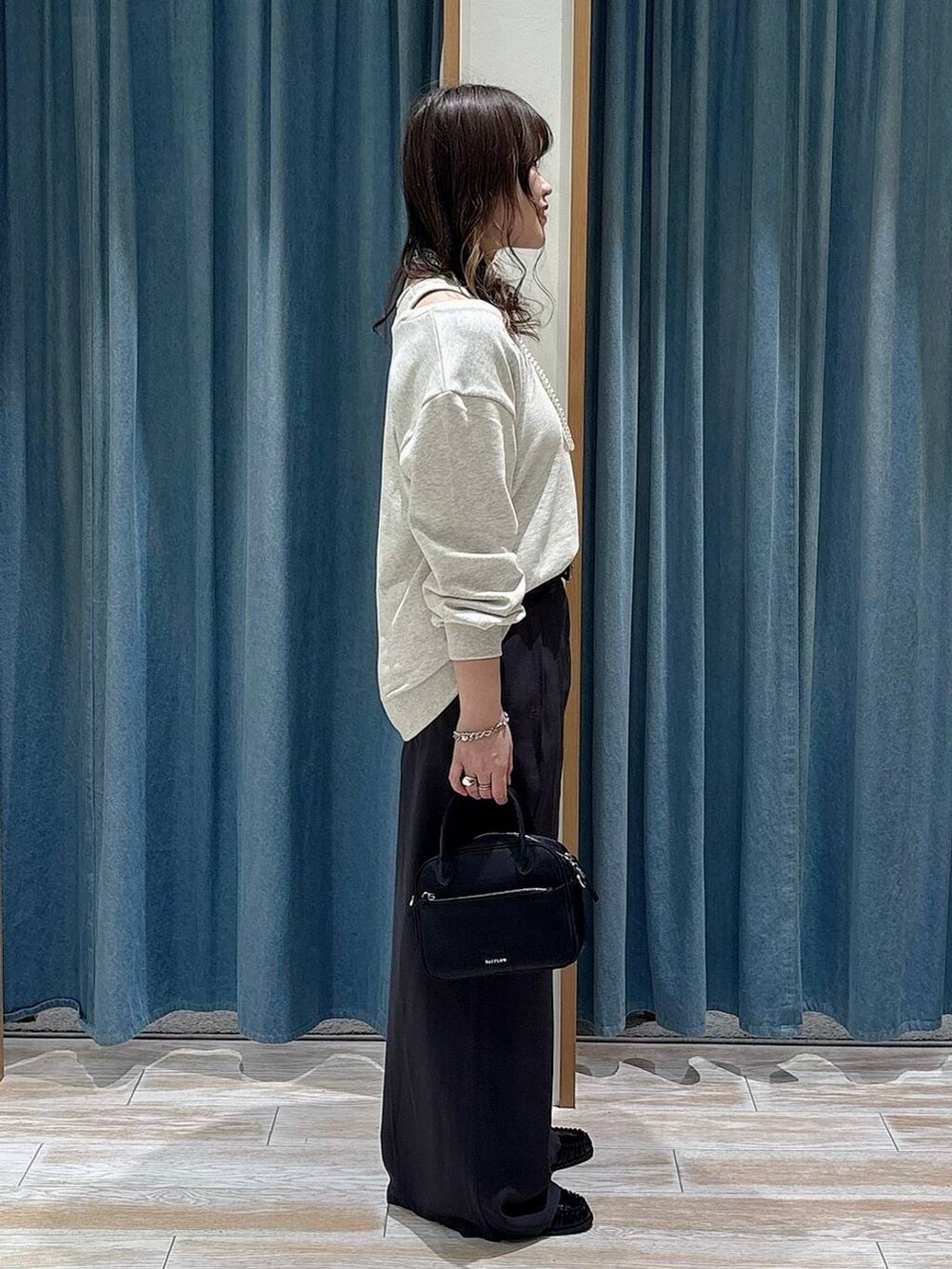 ブラック系のハンドバッグ、ブラック系のローファー、グレー系のその他パンツを着用したレディースの冬コーディネートの2枚目の写真