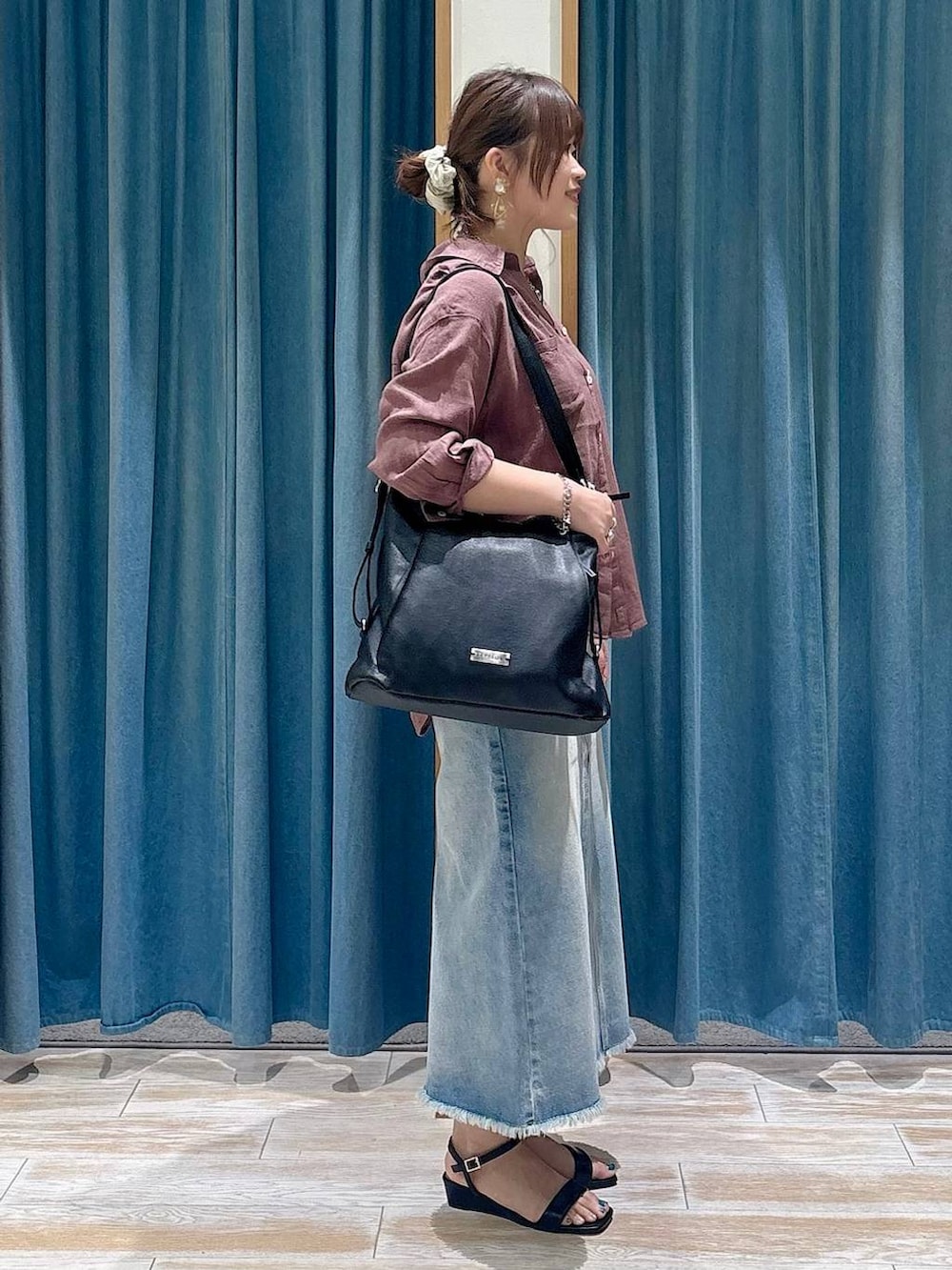 ブラウン系のシャツ/ブラウス、ブルー系のデニムスカート、ブラック系のトートバッグを着用したレディースの春コーディネートの2枚目の写真