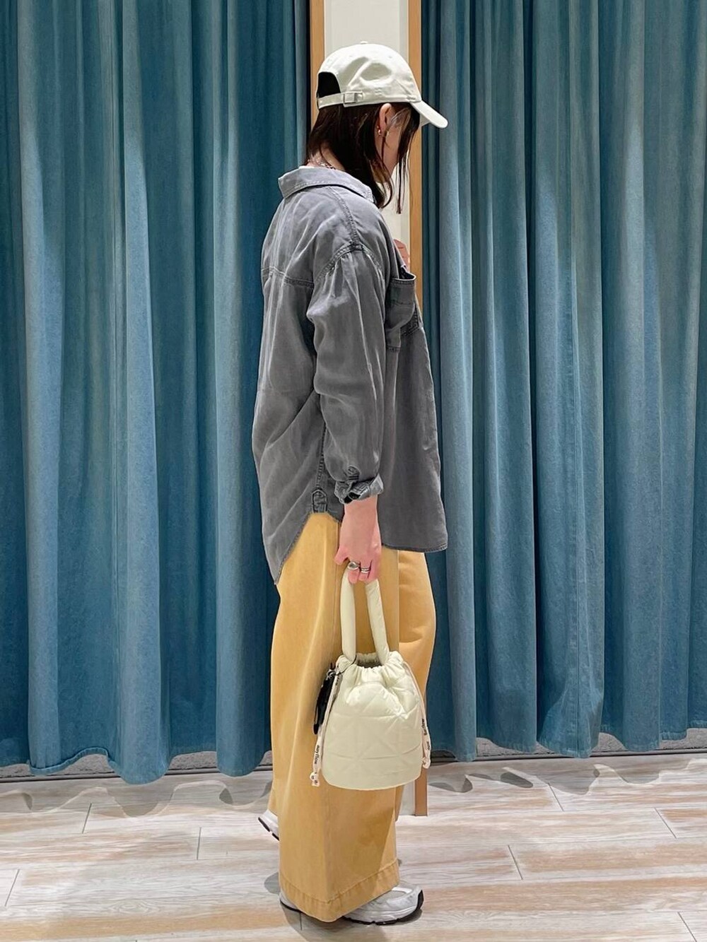 グレー系のシャツ/ブラウス、ホワイト系のTシャツ/カットソー、ベージュ系のショルダーバッグを着用したレディースの春コーディネートの2枚目の写真