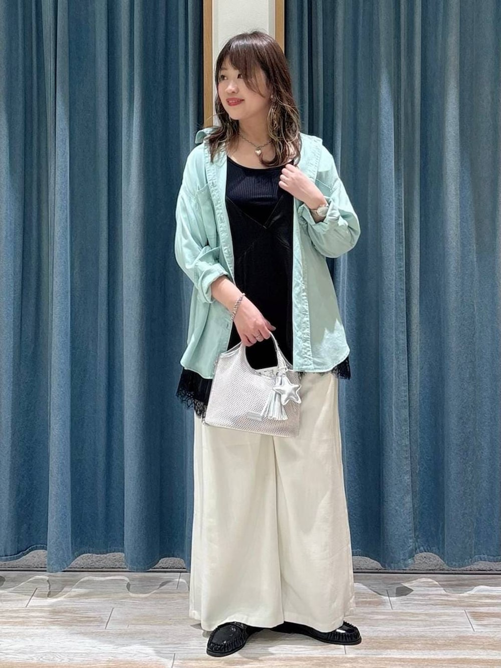 グリーン系のシャツ/ブラウス、ブラック系のローファー、グレー系のショルダーバッグを着用したレディースの春コーディネートの4枚目の写真