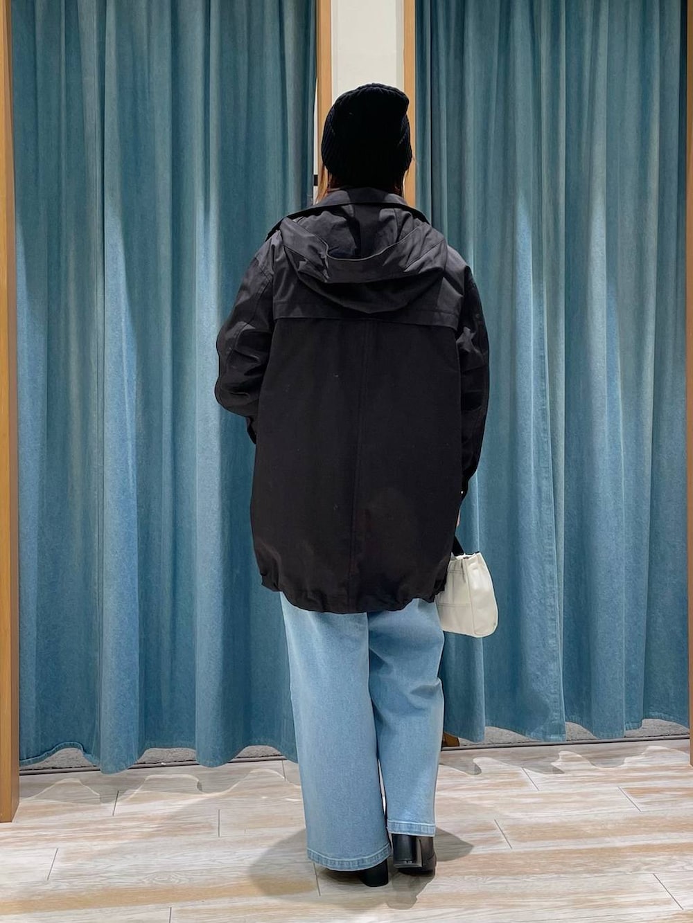 ブラック系のブーツ、オレンジ系のニット/セーター、ブラック系のマウンテンパーカーを着用したレディースの冬コーディネートの3枚目の写真