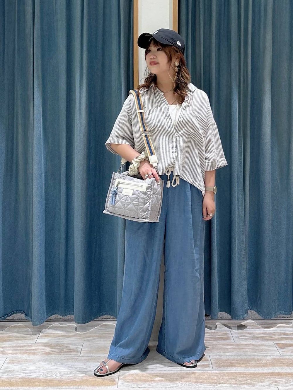 グレー系のショルダーバッグ、ブルー系のデニムパンツ、グレー系のシャツ/ブラウスを着用したレディースの春コーディネートの4枚目の写真
