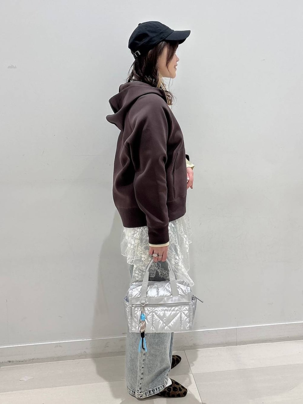 その他のパンプス、シルバー系のボストンバッグ、ブラウン系のパーカーを着用したレディースの冬コーディネートの2枚目の写真