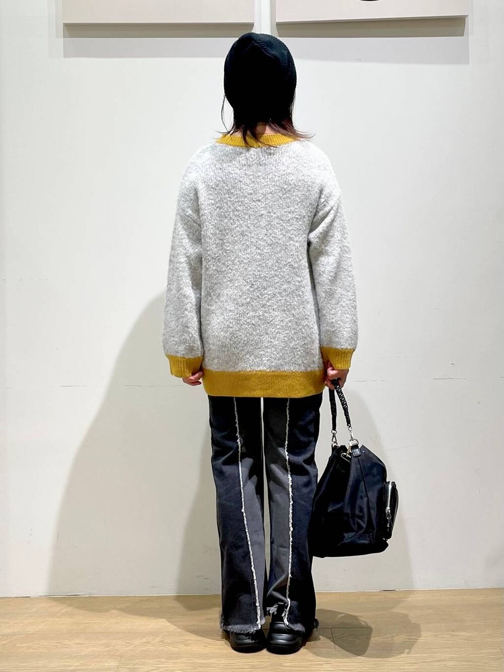 ブラック系のショルダーバッグ、ブラック系のローファー、ブラック系のデニムパンツを着用したレディースの秋コーディネートの3枚目の写真