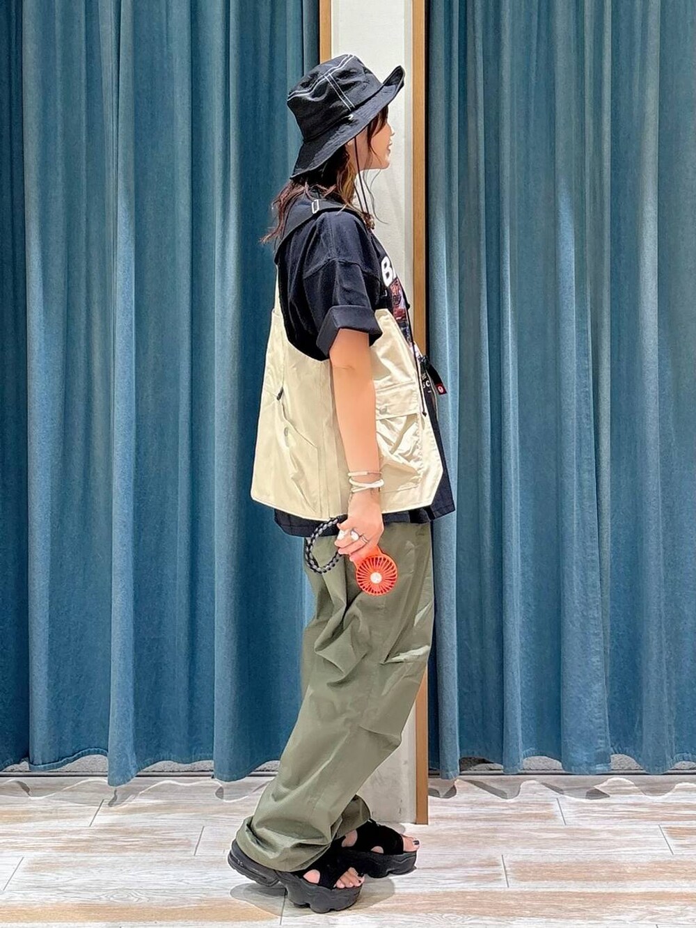 ブラック系のTシャツ/カットソー、グリーン系のその他パンツ、ベージュ系のベストを着用したレディースの夏コーディネートの2枚目の写真