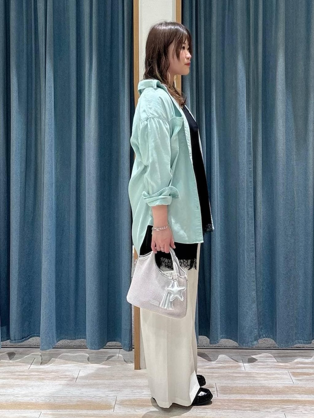 グリーン系のシャツ/ブラウス、ブラック系のローファー、グレー系のショルダーバッグを着用したレディースの春コーディネートの2枚目の写真