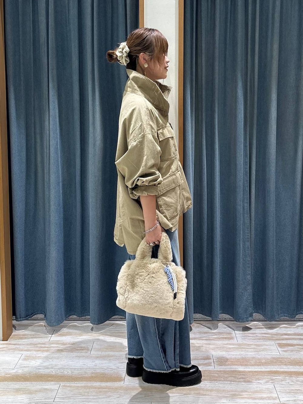 ブルー系のデニムパンツ、ベージュ系のトートバッグ、ベージュ系のブルゾンを着用したレディースの秋コーディネートの2枚目の写真
