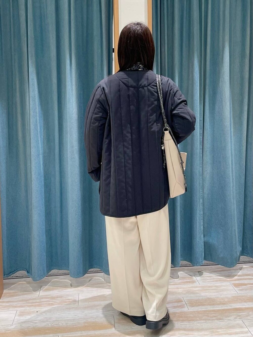 ホワイト系のニット/セーター、ブラック系のその他アウター、ベージュ系のその他パンツを着用したレディースの冬コーディネートの3枚目の写真