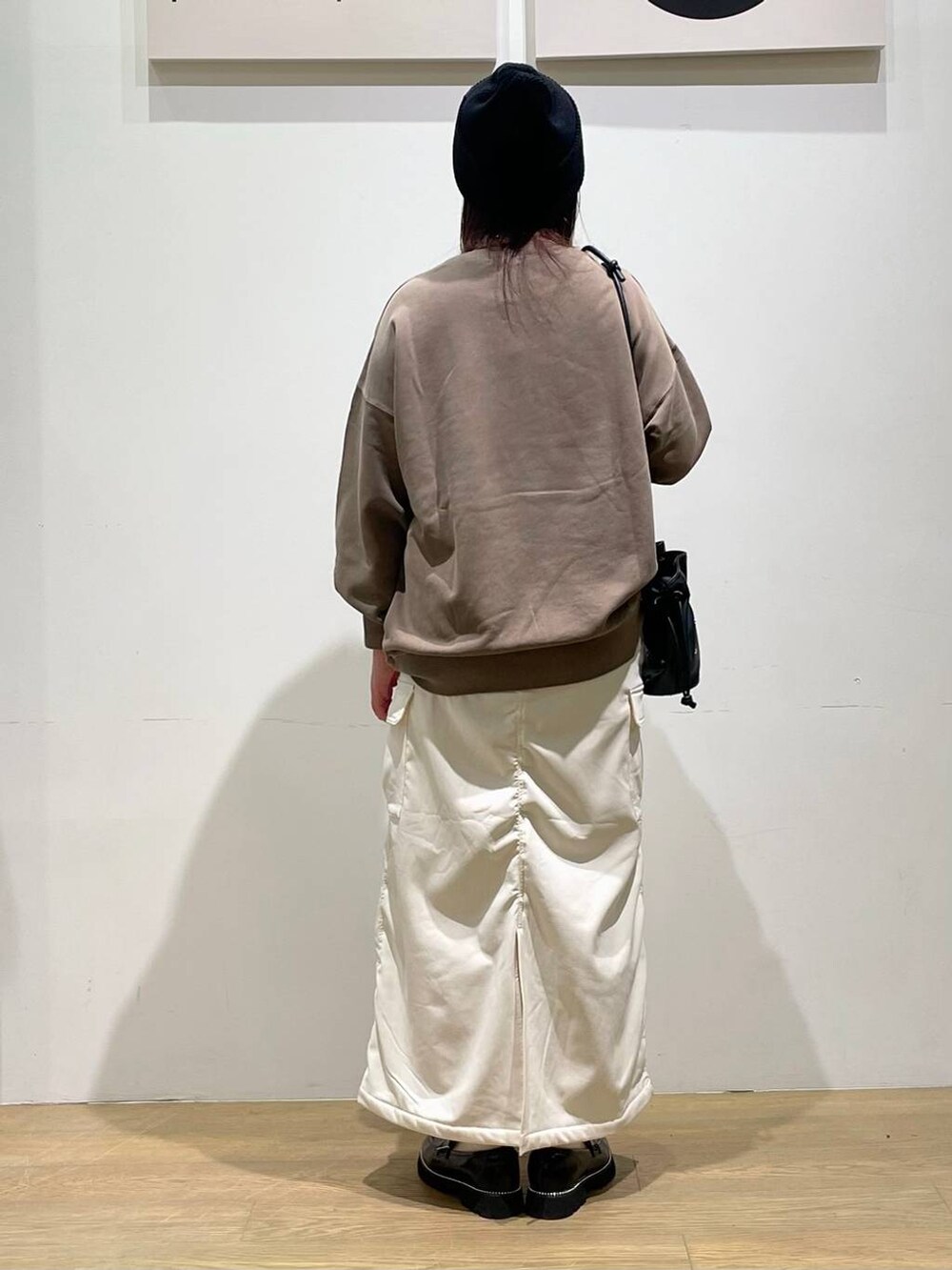 ブラック系のローファー、ブラック系のショルダーバッグ、ホワイト系のスカートを着用したレディースの秋コーディネートの3枚目の写真