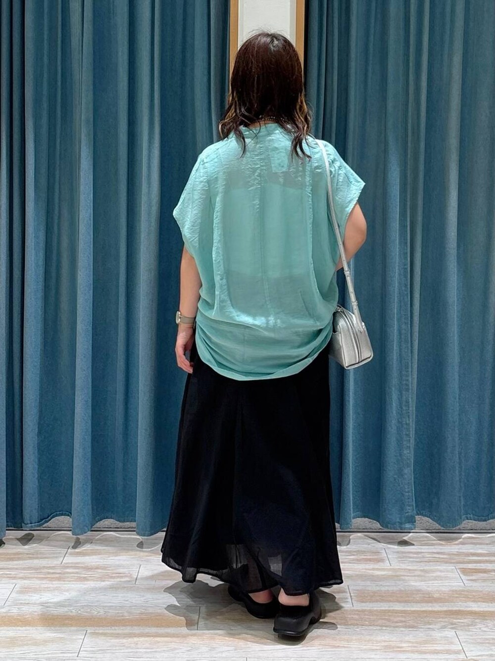 ホワイト系のキャミソール、グリーン系のシャツ/ブラウス、ブラック系のスカートを着用したレディースの夏コーディネートの3枚目の写真