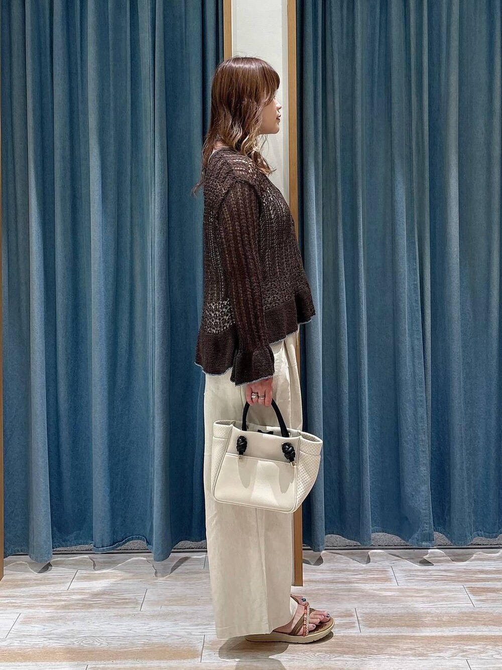 ホワイト系のその他パンツ、ゴールド系のサンダル、ベージュ系のショルダーバッグを着用したレディースの夏コーディネートの2枚目の写真
