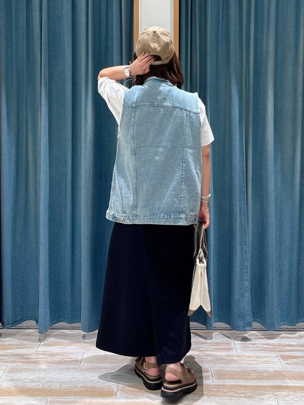 ベージュ系のトートバッグ、ベージュ系のサンダル、ホワイト系のTシャツ/カットソーを着用したレディースの夏コーディネートの3枚目の写真