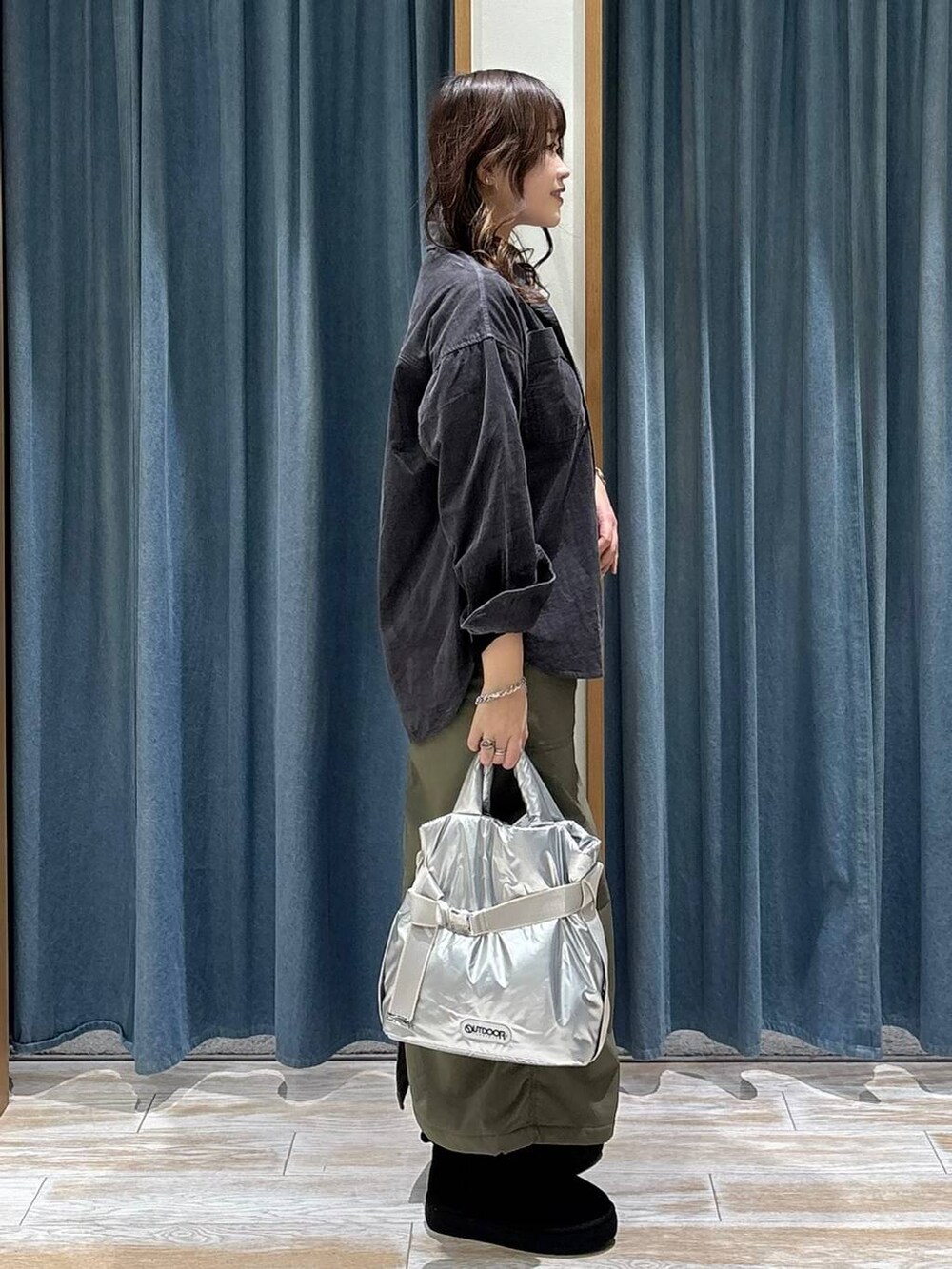 シルバー系のトートバッグ、グリーン系のスカート、グレー系のシャツ/ブラウスを着用したレディースの秋コーディネートの2枚目の写真