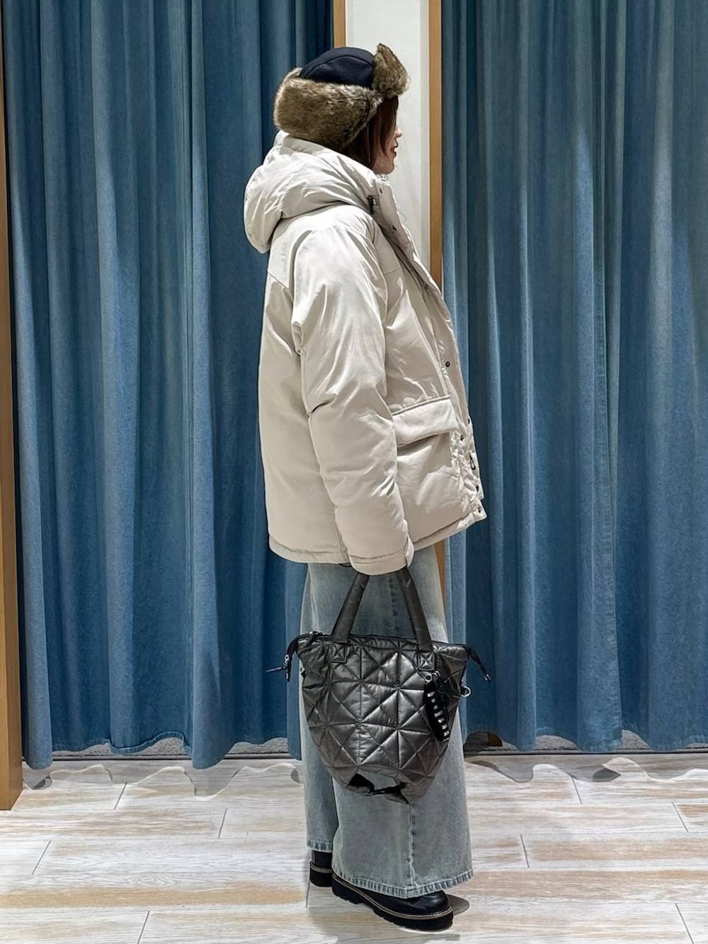 ブラック系のローファー、ベージュ系のダウンジャケット/コート、ブルー系のデニムパンツを着用したレディースの冬コーディネートの2枚目の写真