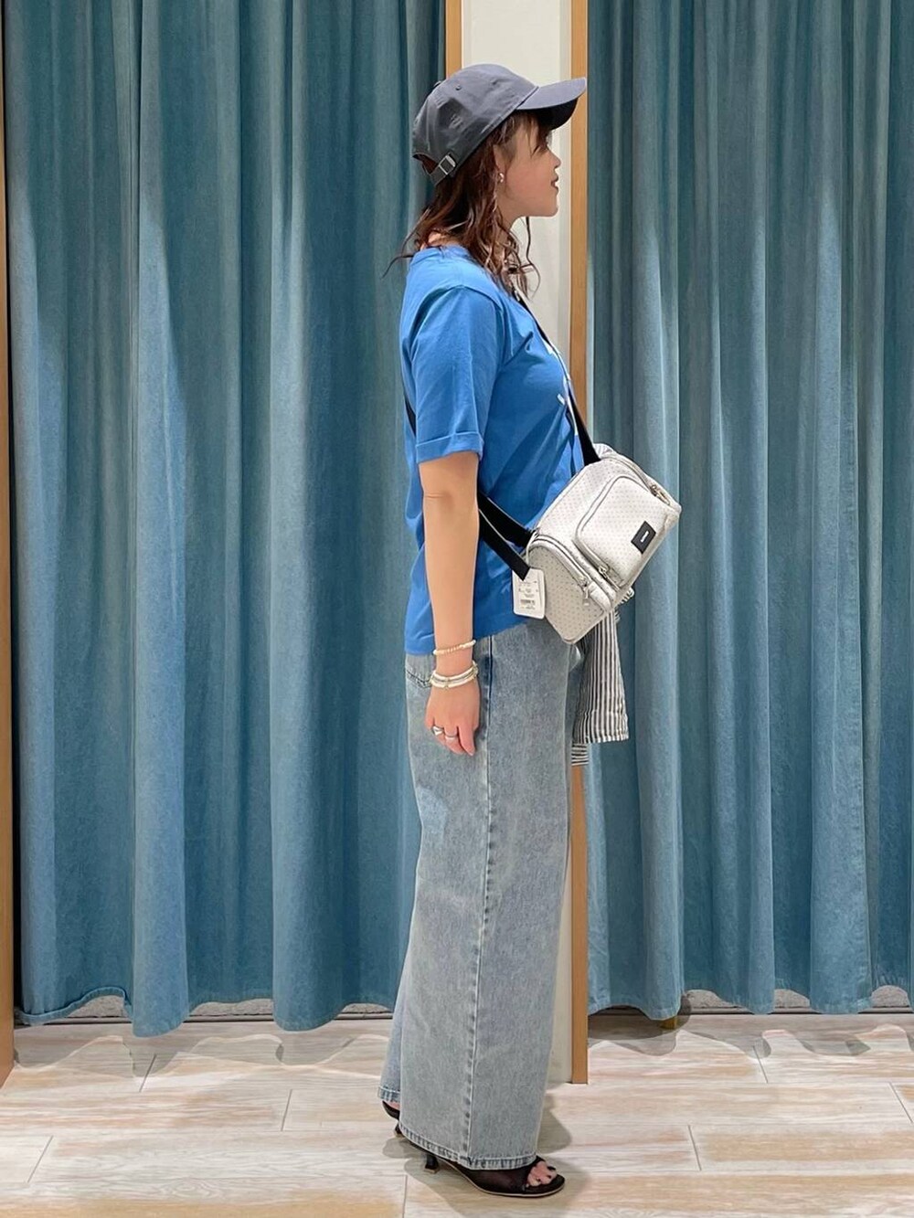 ブルー系のデニムパンツ、ブルー系のシャツ/ブラウス、ブラック系のサンダルを着用したレディースの春コーディネートの2枚目の写真