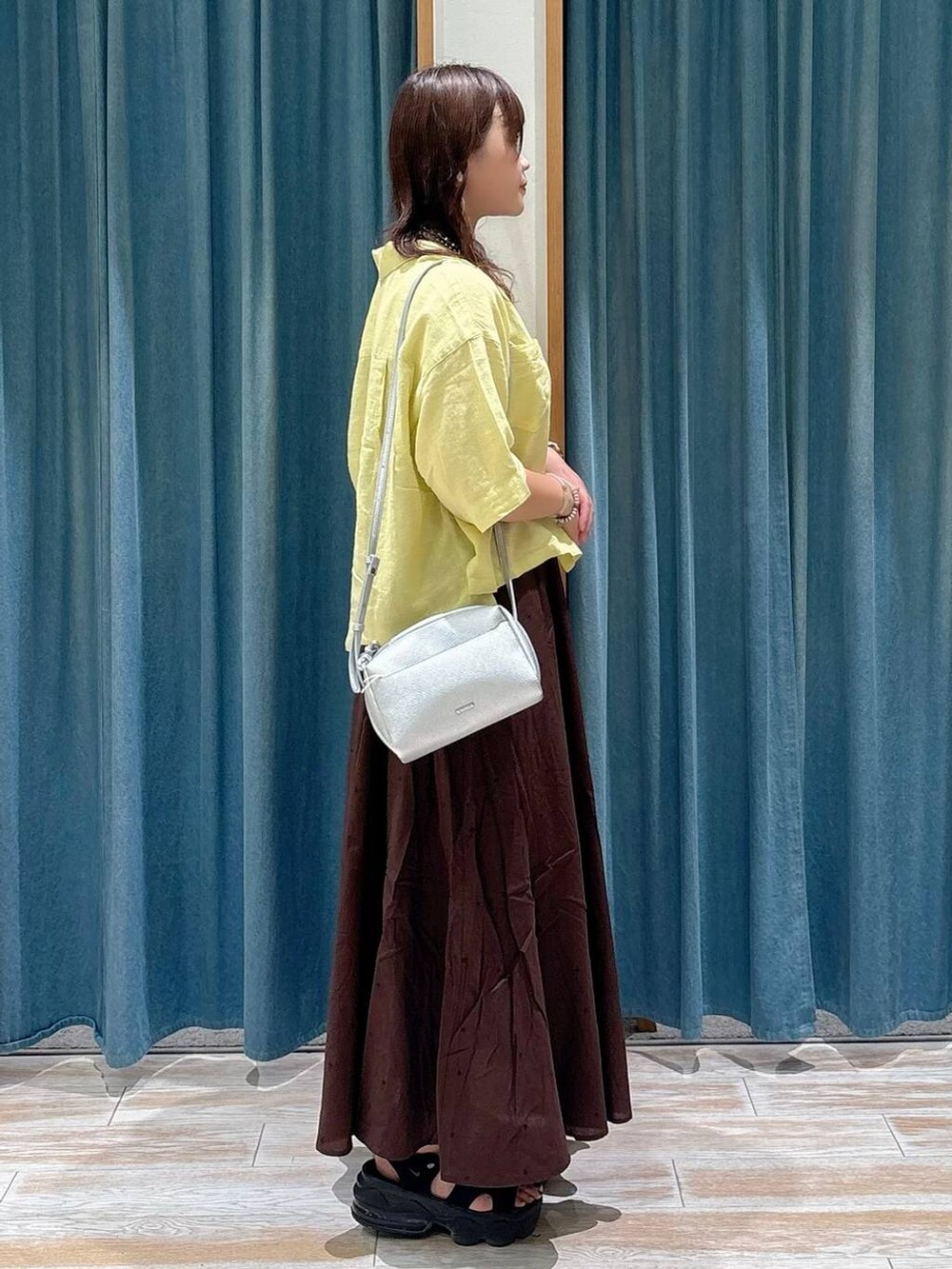 ブラック系のキャミソール、シルバー系のショルダーバッグ、イエロー系のシャツ/ブラウスを着用したレディースの夏コーディネートの2枚目の写真