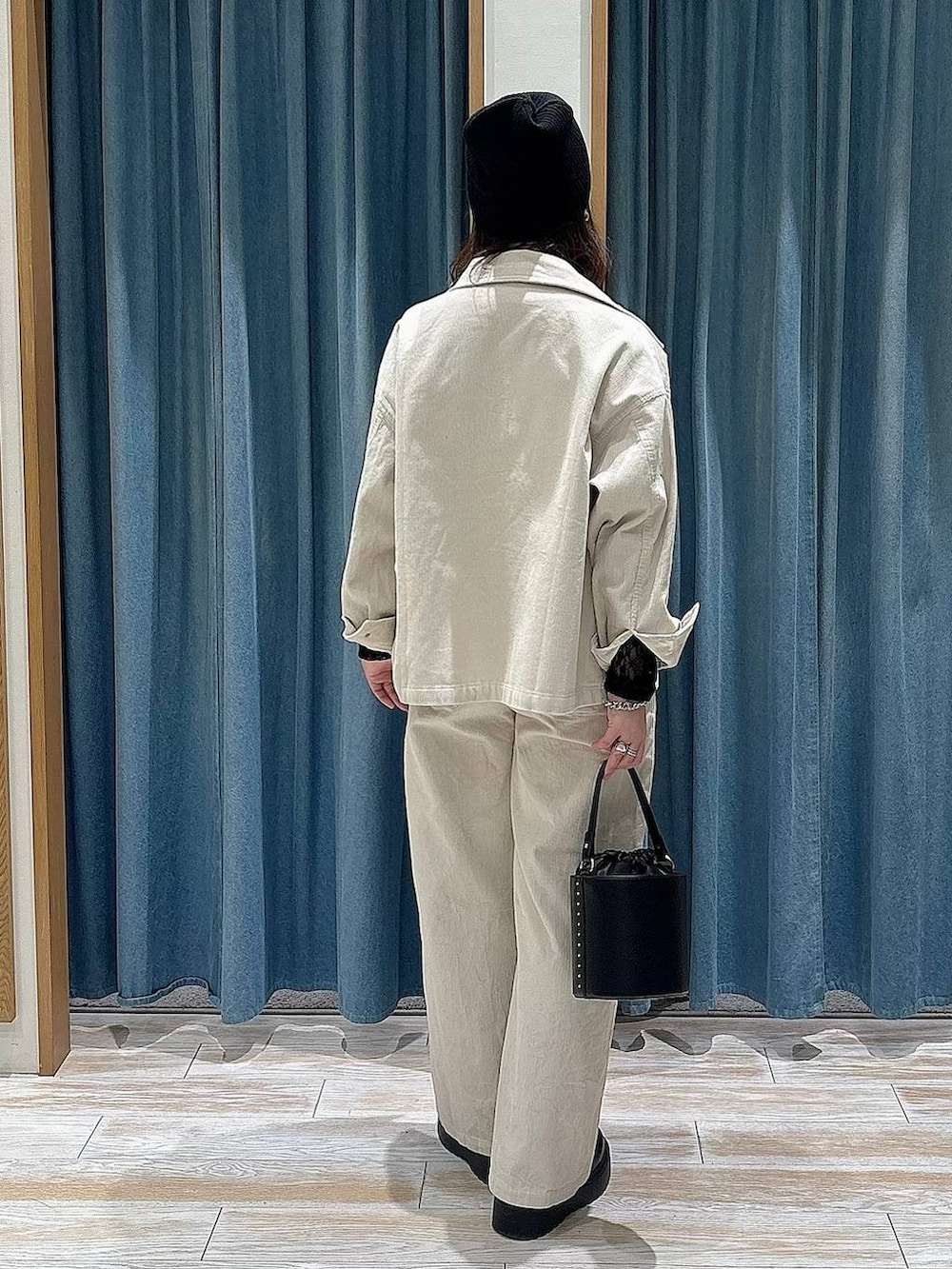 ブラック系のブーツ、ブラック系のTシャツ/カットソー、ブラック系のハンドバッグを着用したレディースの冬コーディネートの3枚目の写真