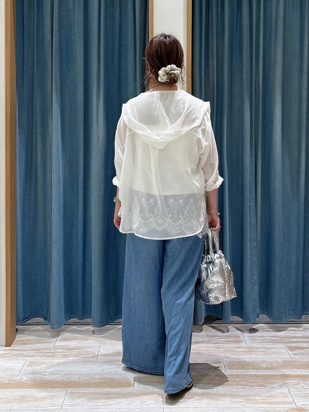 ブルー系のデニムパンツ、シルバー系のショルダーバッグ、シルバー系のサンダルを着用したレディースの春コーディネートの3枚目の写真