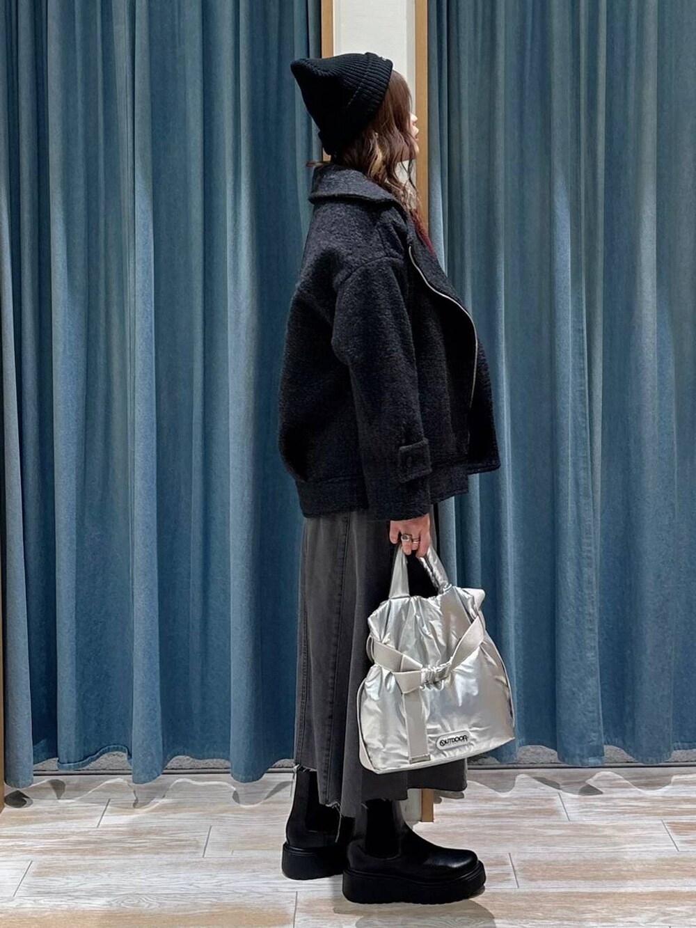 シルバー系のトートバッグ、ブラック系のブーツ、グレー系のその他アウターを着用したレディースの秋コーディネートの2枚目の写真