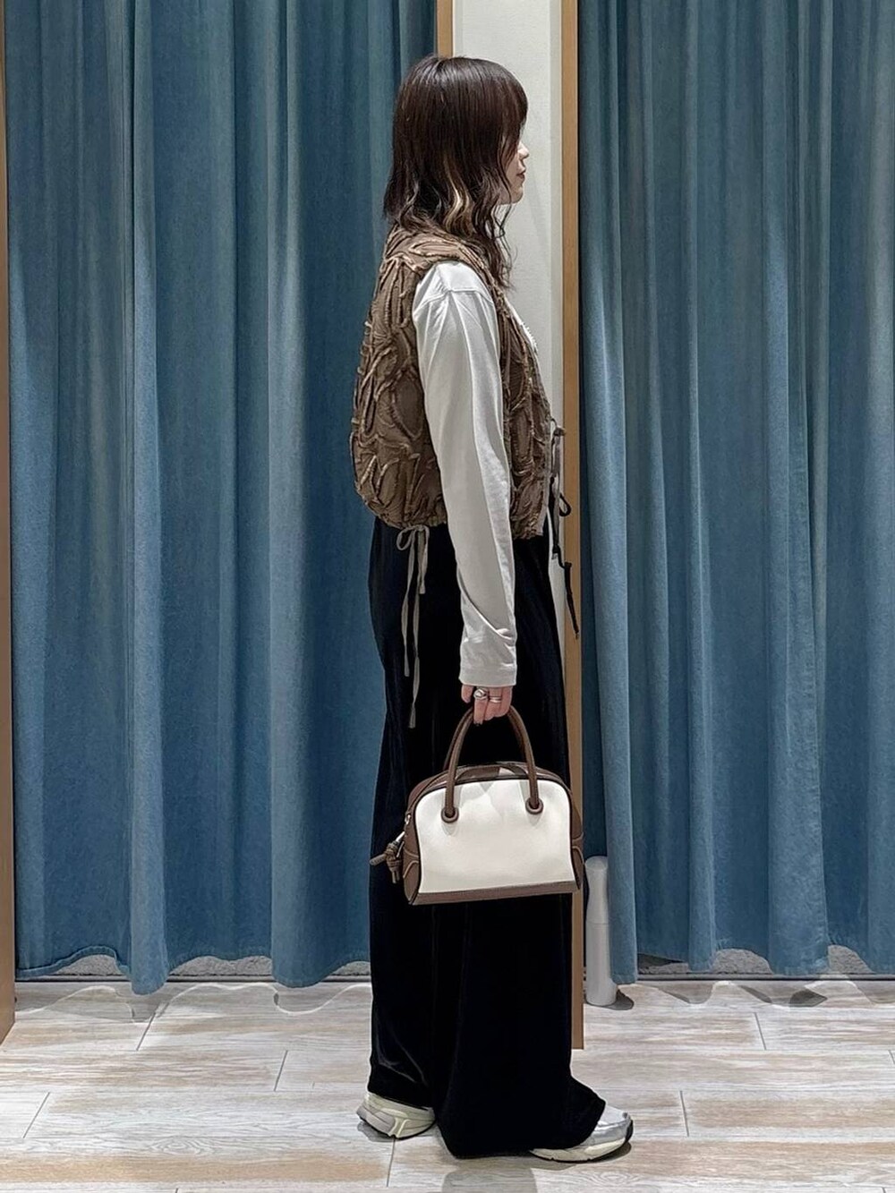 グレー系のTシャツ/カットソー、ホワイト系のハンドバッグ、ブラック系のその他パンツを着用したレディースの秋コーディネートの2枚目の写真