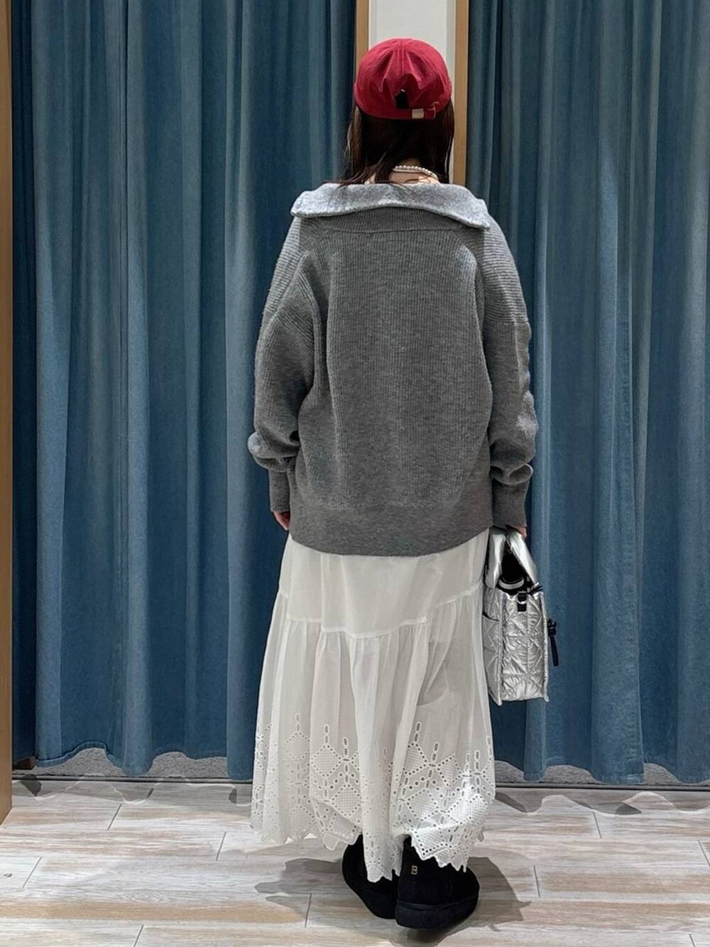 シルバー系のショルダーバッグ、ブラック系のブーツ、ブラック系のニット/セーターを着用したレディースの秋コーディネートの3枚目の写真