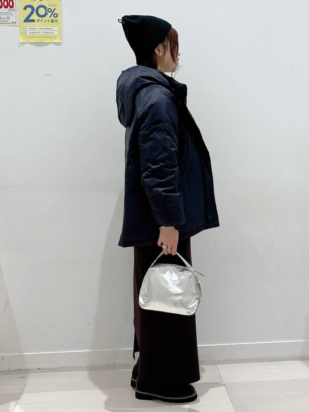 シルバー系のショルダーバッグ、ブラック系のダウンジャケット/コート、ブラック系のローファーを着用したレディースの秋コーディネートの2枚目の写真