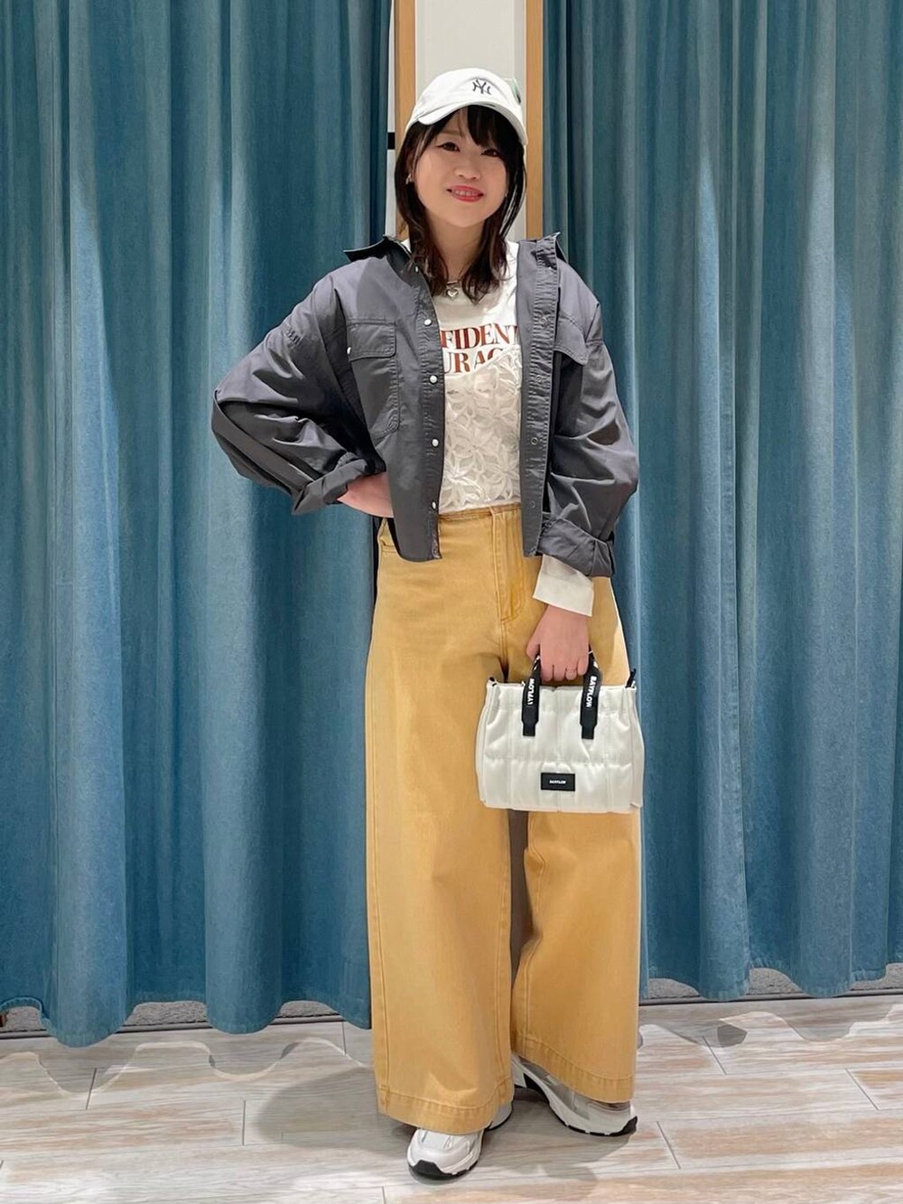 グレー系のシャツ/ブラウス、ベージュ系のショルダーバッグ、ホワイト系のスニーカーを着用したレディースの冬コーディネートの4枚目の写真