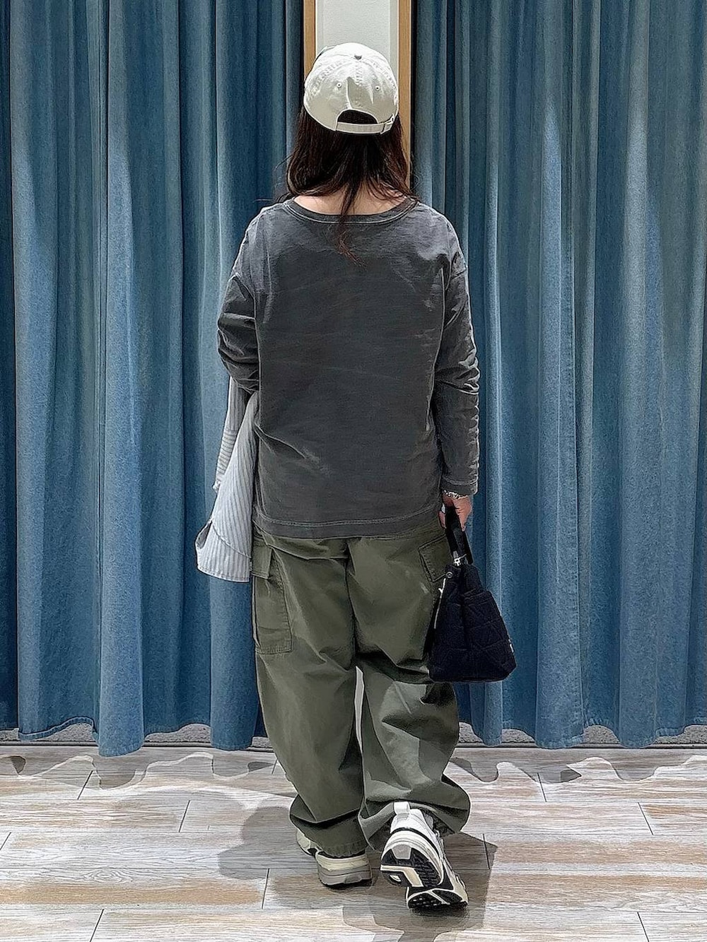 ブラック系のトートバッグ、グレー系のTシャツ/カットソー、グリーン系のカーゴパンツを着用したレディースの春コーディネートの3枚目の写真
