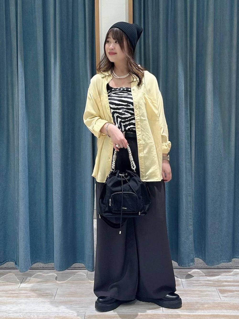 ブラック系のブーツ、ブラック系のハンドバッグ、イエロー系のシャツ/ブラウスを着用したレディースの冬コーディネートの4枚目の写真