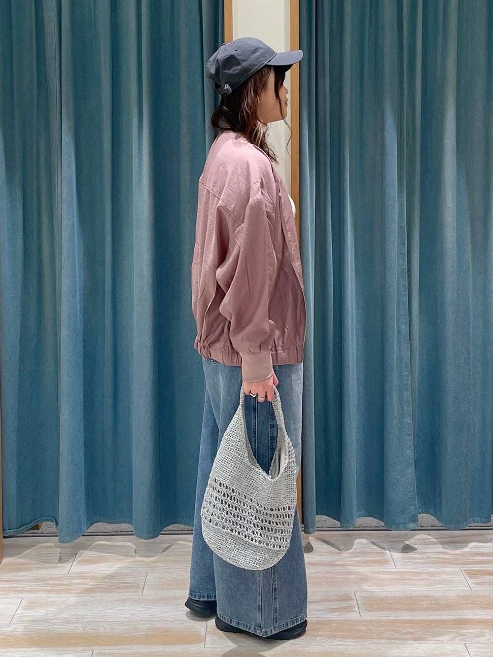 ホワイト系のキャミソール、ブルー系のデニムパンツ、グレー系のハンドバッグを着用したレディースの春コーディネートの2枚目の写真