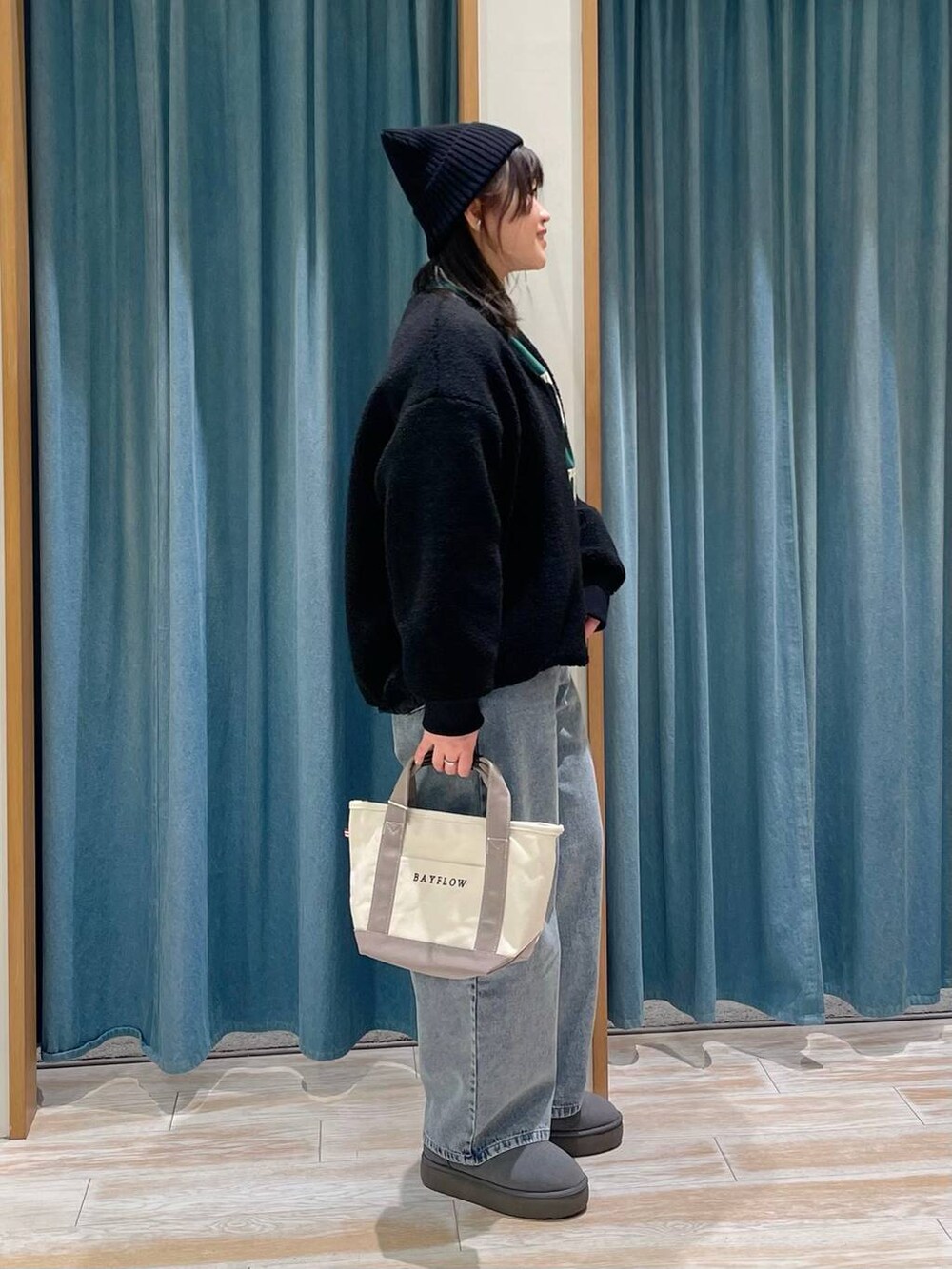 ブラック系のブルゾン、グレー系のトートバッグ、グリーン系のTシャツ/カットソーを着用したレディースの冬コーディネートの2枚目の写真