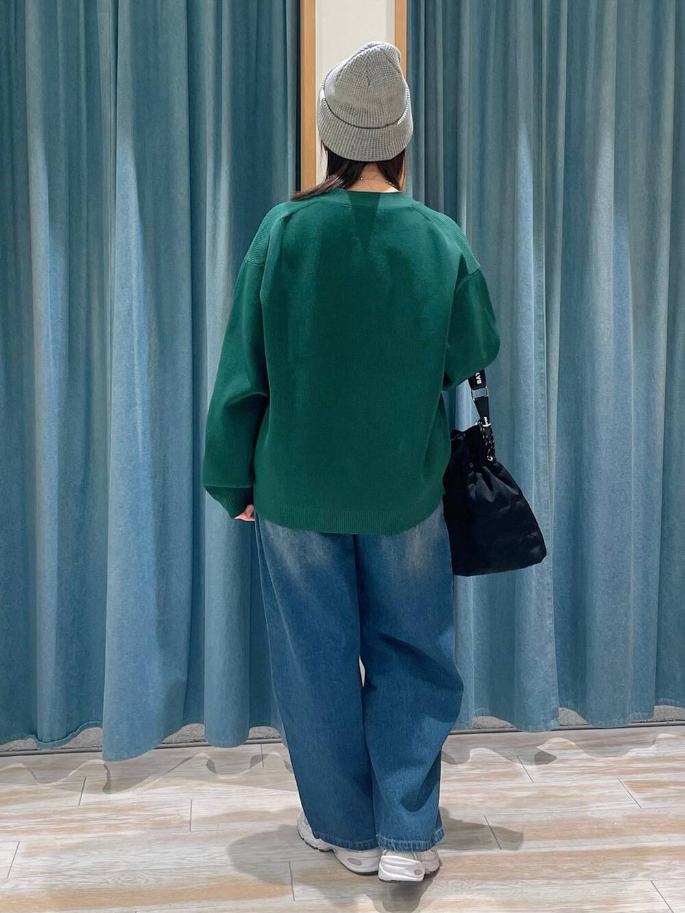 ホワイト系のキャミソール、ブルー系のデニムパンツ、ブラック系のショルダーバッグを着用したレディースの冬コーディネートの3枚目の写真