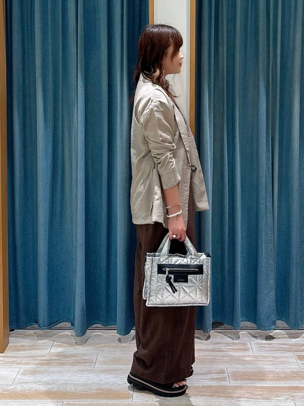 ブラック系のキャミソール、ブラウン系のサンダル、シルバー系のショルダーバッグを着用したレディースの夏コーディネートの2枚目の写真