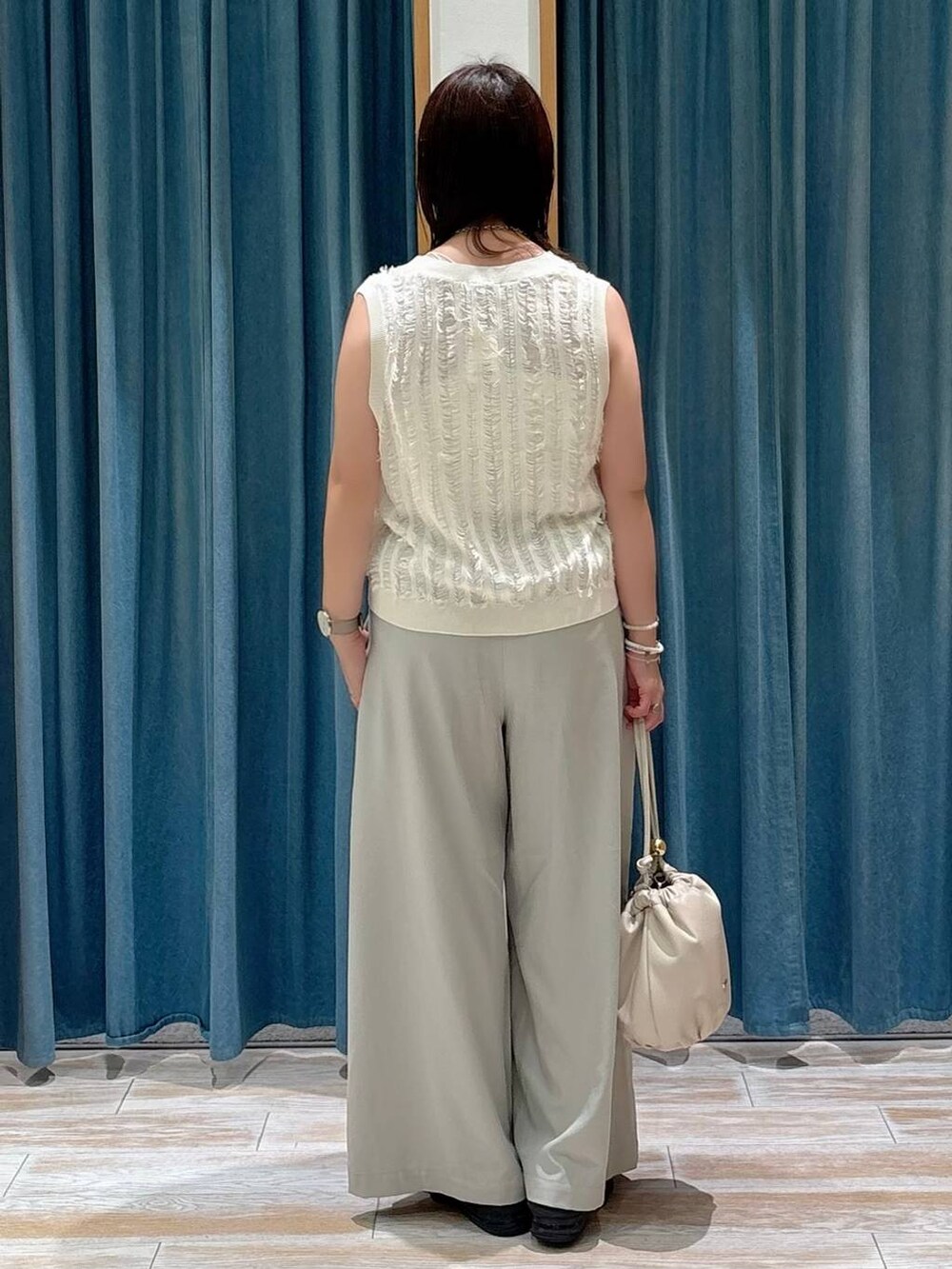 ベージュ系のその他パンツ、ホワイト系のショルダーバッグ、ホワイト系のベストを着用したレディースの夏コーディネートの3枚目の写真