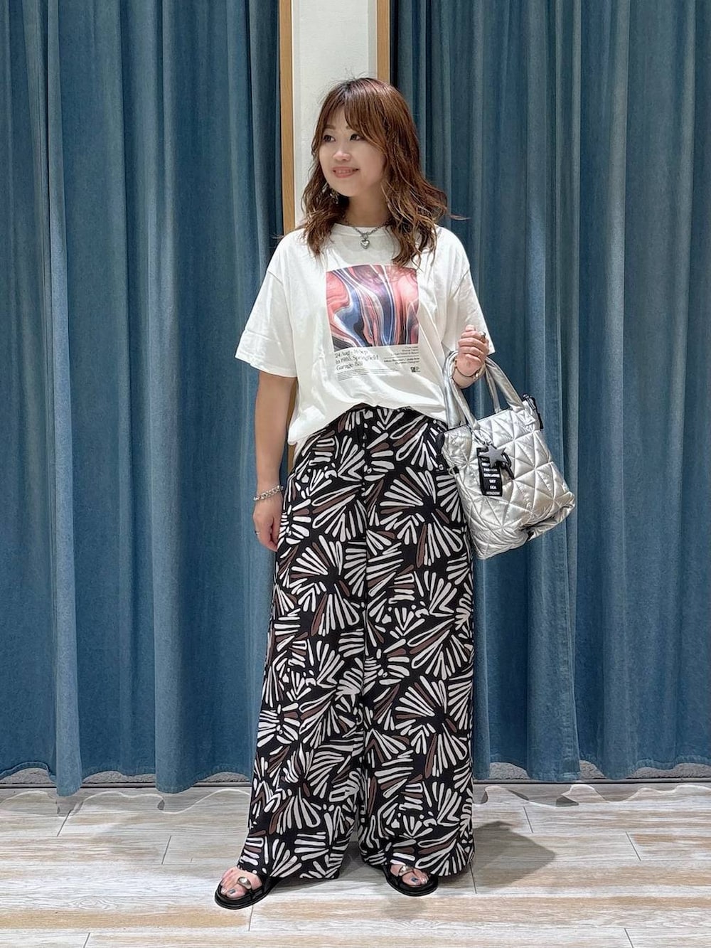 ホワイト系のTシャツ/カットソー、ブラック系のその他パンツ、シルバー系のトートバッグを着用したレディースの夏コーディネートの4枚目の写真