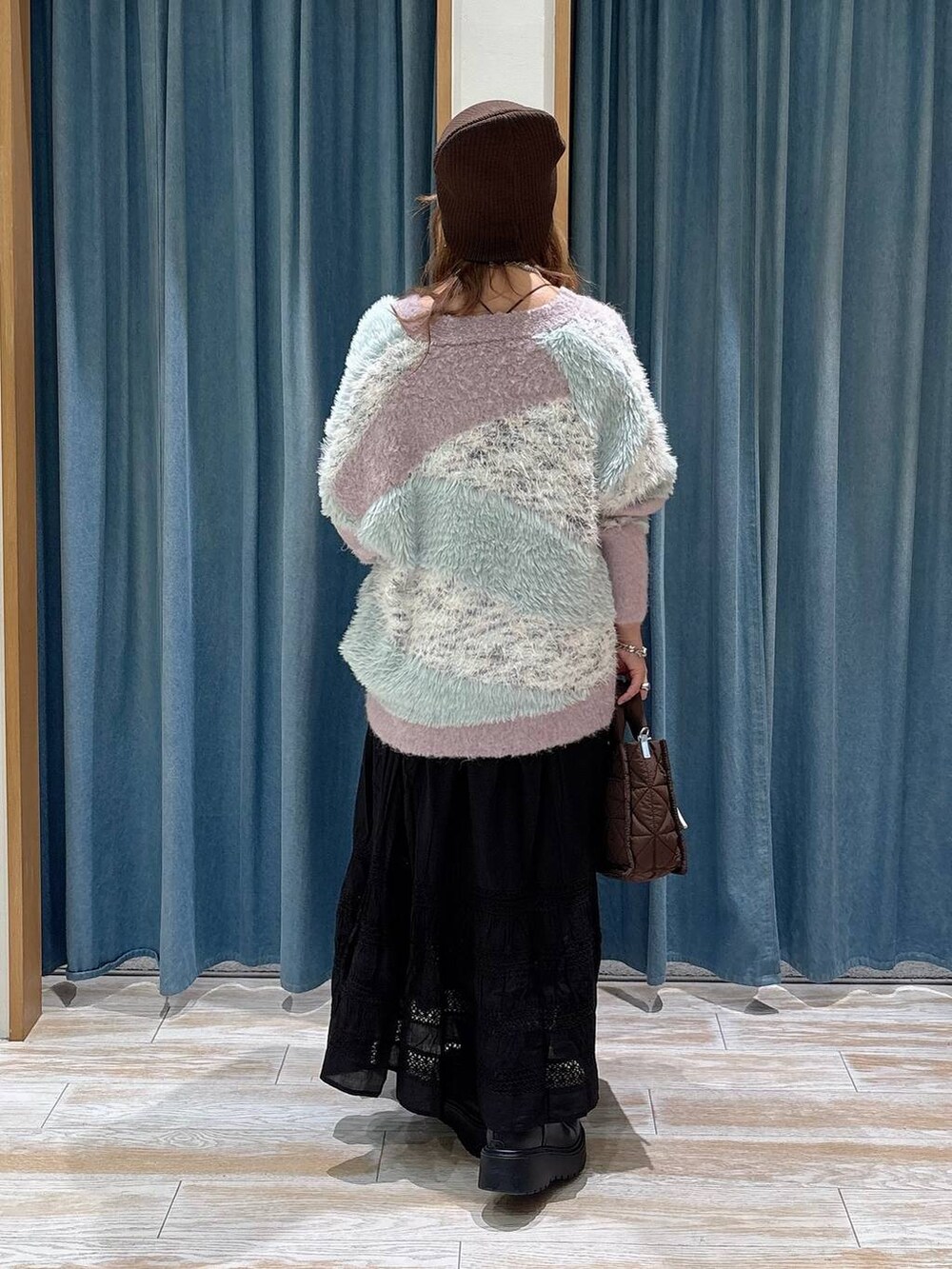 パープル系のカーディガン/ボレロ、ブラウン系のショルダーバッグ、ブラック系のブーツを着用したレディースの秋コーディネートの3枚目の写真