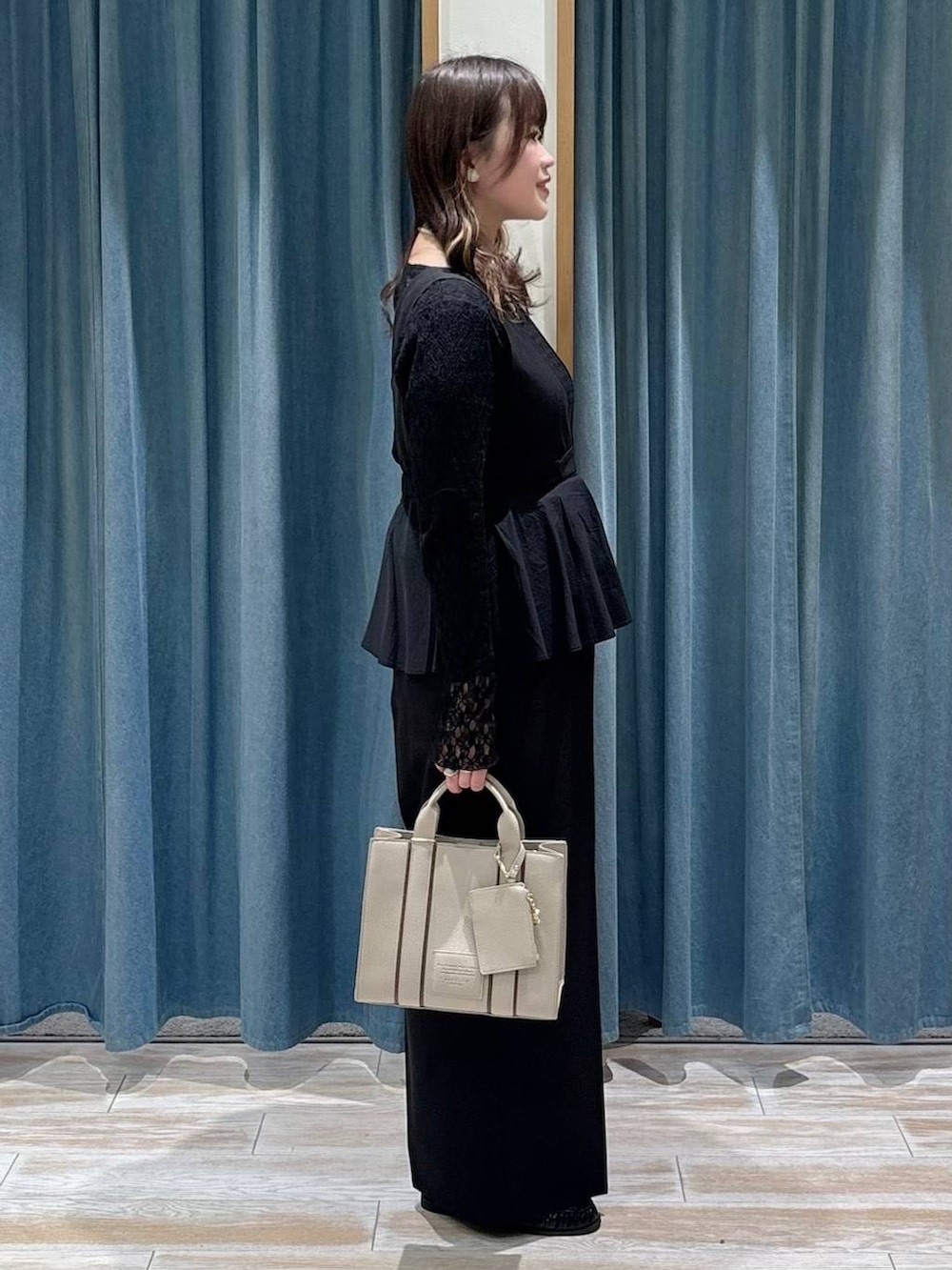 ブラック系のTシャツ/カットソー、ブラック系のつなぎ/オールインワン、ベージュ系のハンドバッグを着用したレディースの冬コーディネートの2枚目の写真