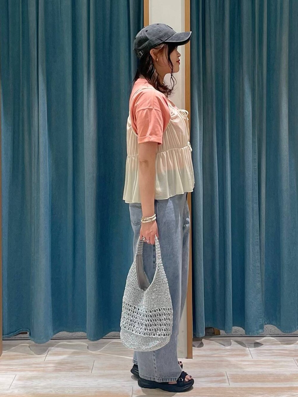 ブルー系のデニムパンツ、ブラウン系のTシャツ/カットソー、グレー系のハンドバッグを着用したレディースの春コーディネートの2枚目の写真