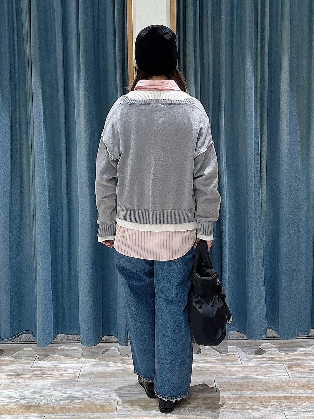 ブラック系のトートバッグ、ブルー系のデニムパンツ、ブラック系のローファーを着用したレディースの冬コーディネートの3枚目の写真