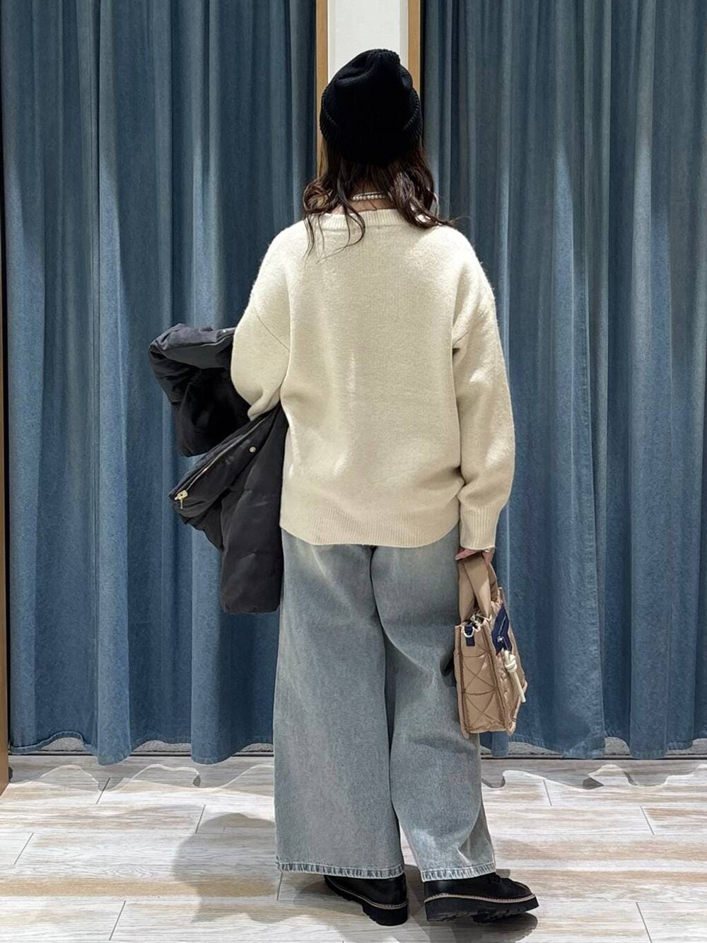 ベージュ系のショルダーバッグ、グレー系のダウンジャケット/コート、ブラック系のローファーを着用したレディースの秋コーディネートの3枚目の写真