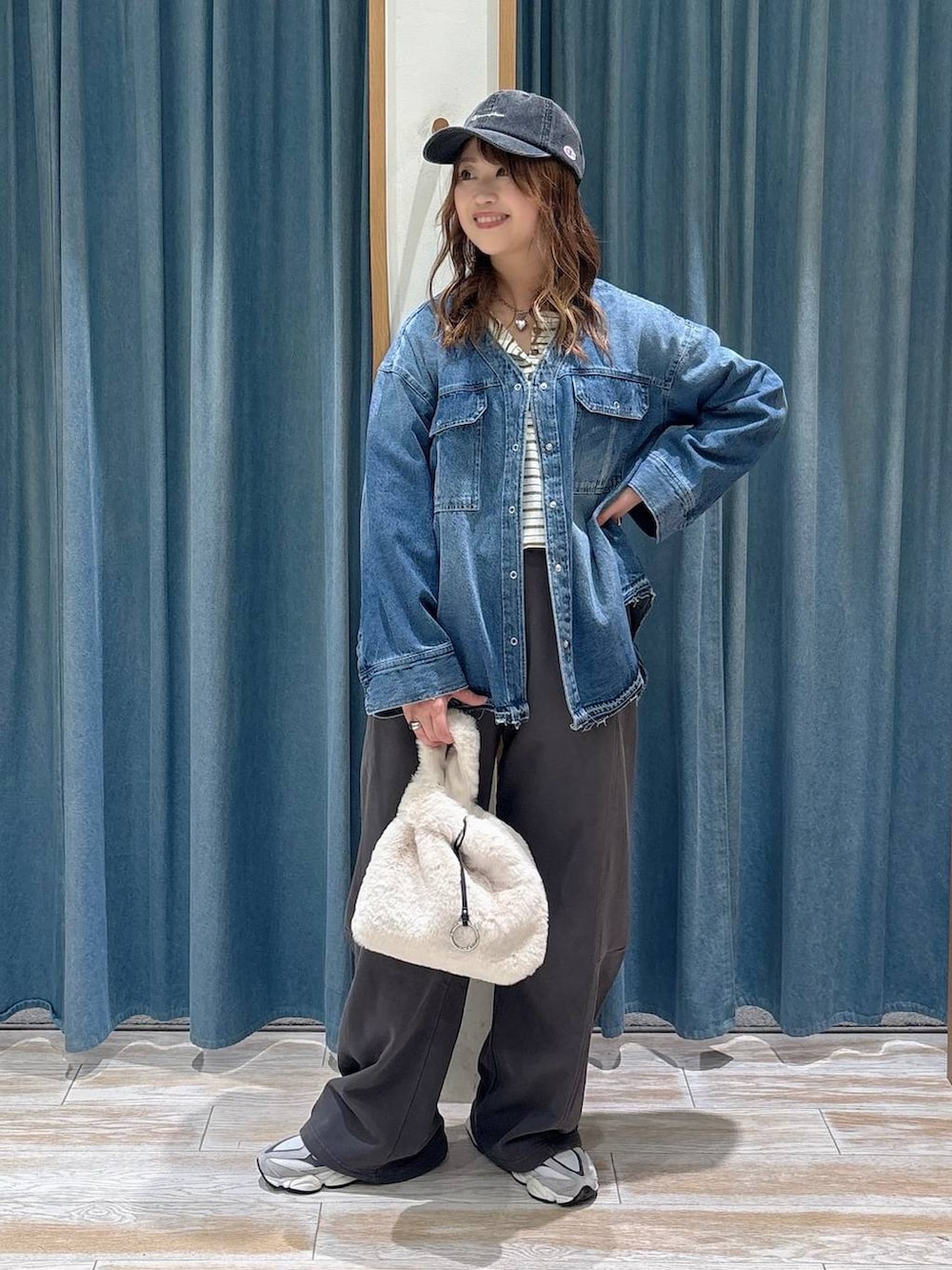 ブルー系のシャツ/ブラウス、グレー系のスウェットパンツ、ベージュ系のハンドバッグを着用したレディースの秋コーディネートの4枚目の写真