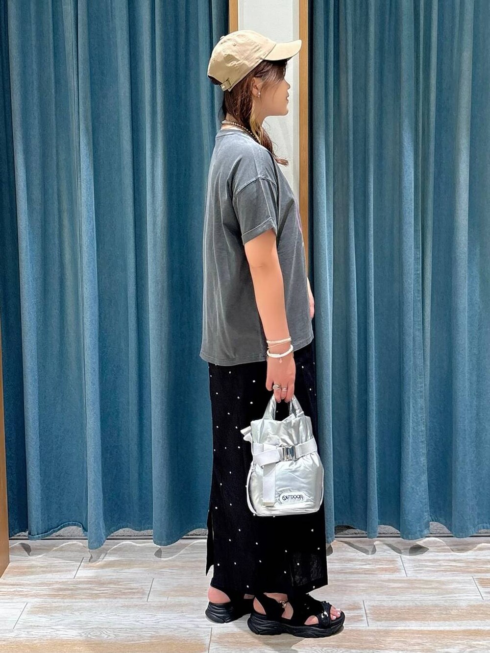 グレー系のTシャツ/カットソー、ブラック系のサンダル、シルバー系のショルダーバッグを着用したレディースの夏コーディネートの2枚目の写真