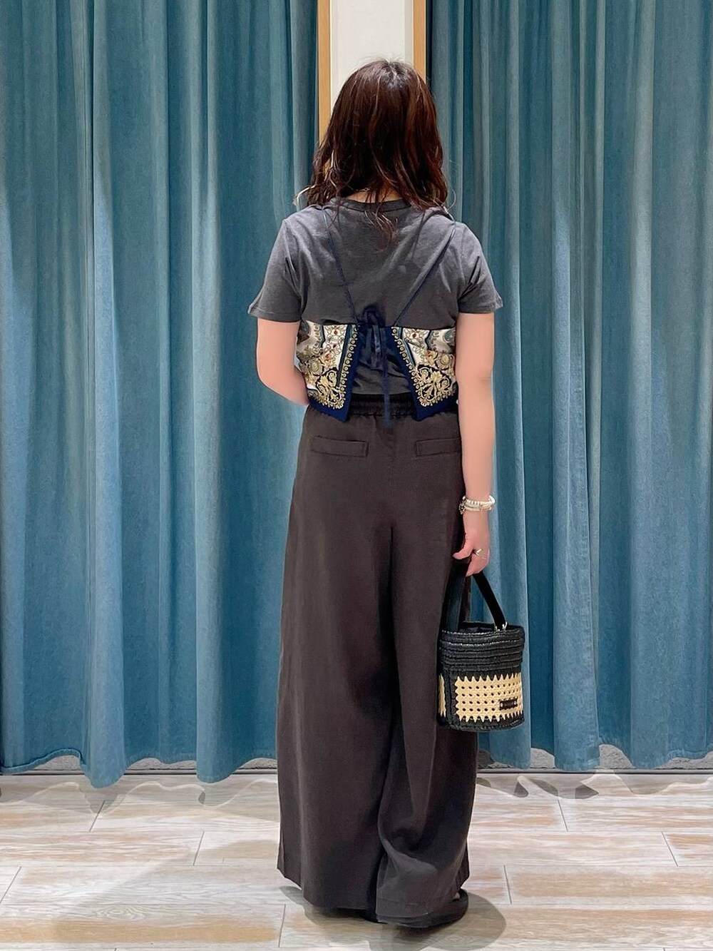 ブラック系のサンダル、ブラック系のショルダーバッグ、ブルー系のキャミソールを着用したレディースの春コーディネートの3枚目の写真